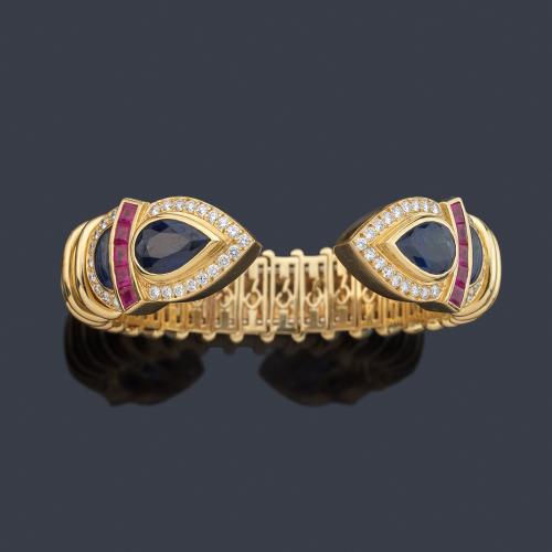 Pulsera rígida con dos remates enfrentados con pareja de zafiros talla perilla y rubíes calibrados de aprox. 18,71 ct en total, y brillantes de aprox. 1,21 ct.