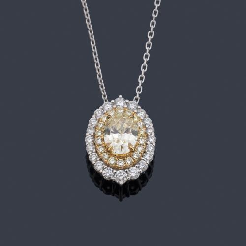 Colgante con diamante 'fancy yellow' talla oval de aprox. 0,79 ct con orla de brillantes de aprox. 0,37 ct y brillantes 'fancy yellow' de aprox. 0,19 ct en total.