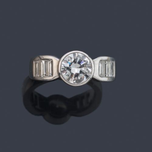 Anillo con brillante central de aprox. 1,20 ct con dos bandas de diamantes talla baguette de aprox. 0,40 ct en total.