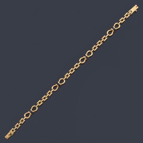 Pulsera con cuatro motivos en forma de lazada con zafiros calibrados en montura de oro amarillo de 18K.