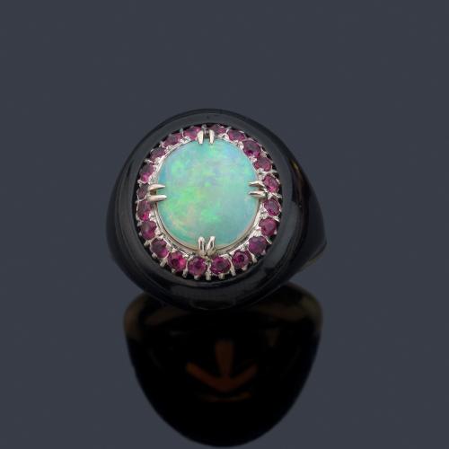 Anillo con ópalo talla cabujón con orla de rubíes sobre montura de esmalte negro y oro amarillo de 18K.