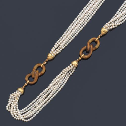 Collar largo con siete hilos de perlitas intercalado con motivo en forma de 'infinito' realizado en cuarzo 'ojo de tigre' con copete estriado en oro amarillo de 18K. Años '70.
