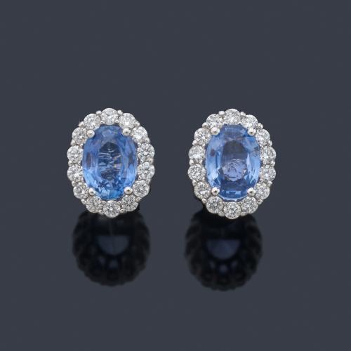 Pendientes cortos con pareja de zafiros talla oval de aprox. 1,95 ct con orla de brillantes de aprox. 0,49 ct en total.