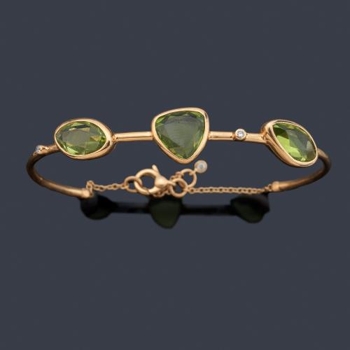 Pulsera semirrígida con tres peridotos facetados intercalados con brillantitos en montura de oro amarillo de 18K.