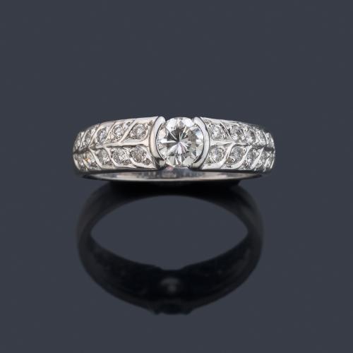 Anillo con brillante central de aprox. 0,35 ct con doble banda de brillantitos en ambos lados.