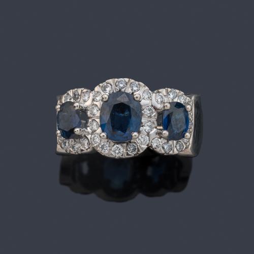 Anillo con tres zafiros talla oval de aprox. 2,00 ct en total con orla de brillantes de aprox. 0,96 ct.