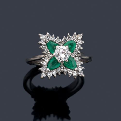 Anillo con diseño floral con brillante central de aprox. 0,30 ct con cuatro esmeraldas talla perilla y orla de diamantes.