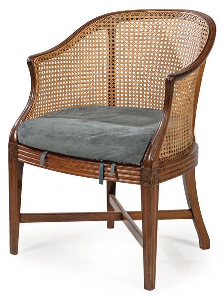 Bergere Luis XVI en madera de caoba tallada, con patas unidas con chambrana en X. Asiento y respaldo de rejilla.