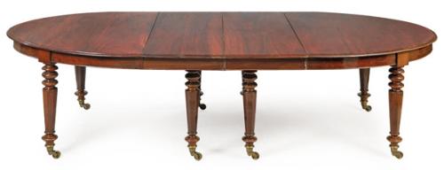 Mesa de comedor extensible William IV, de forma ovalada en madera de caoba, sobre patas facetadas y torneadas. Con 8 extensiones suplementarias.
