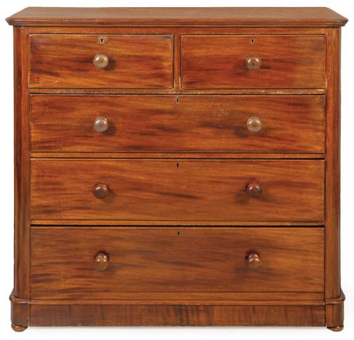 Cómoda Victoriana en madera de caoba, con dos cajones cortos sobre tres largos de altura decreciente y tiradores torneados.