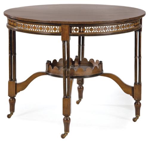 Mesa de centro estilo Chippendale en madera de caoba, con faldón calado con decoración de formas geométricas. Sobre patas formadas por cuatro columnas torneadas, unidas al centro por balda con barandilla recortada.