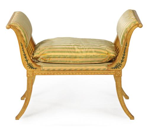 Banqueta estilo Imperio en madera tallada y dorada, con brazos y patas curvos. Tapicería de seda.
