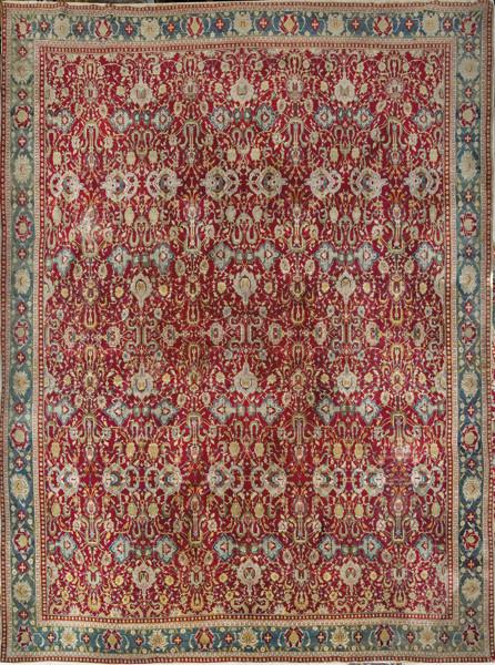 Alfombra persa tipo Tabriz en lana con campo rojo y decoración de palmetas y motivos vegetales.