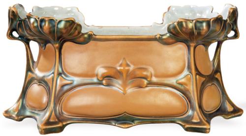  Jardinera Art Nouveau en gres esmaltado en color cobre dorado, con  asas florales de nenúfar en relieve. Procedencia