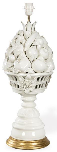  Lámpara de mesa en cerámica  esmaltada en blanco de Manises en forma de copa modelada en altorrelieve con frutos y hojas, pie torneado, base en madera dorada.