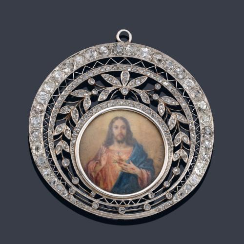 Medalla devocional época 'art decó' con La Imagen del Sagrado Corazón de Jesús firmado 'A. Maura' con orla vegetal y geométrica con diamantes talla antigua. Circa 1930.