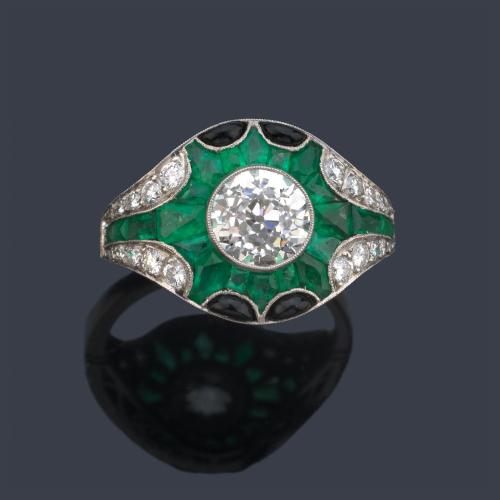  Anillo con diamante talla 'old cut' central de aprox. 1,55 ct con orla de esmeraldas calibradas de aprox. 3,40 ct en total y ónix.