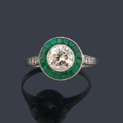 Anillo 'ojo de perdiz' con diamante talla transición de aprox. 0,97 ct y orla de esmeraldas calibradas de aprox. 1,00 ct en total.