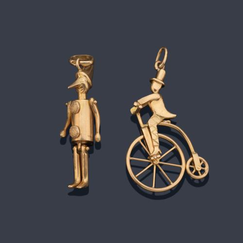 Dos colgantes realizados en oro amarillo de 18K con forma de 'pinocho' y bicicleta de rueda alta.