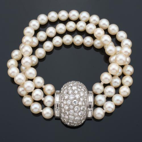 Pulsera con tres hilos de perlas de aprox. 6,95 mm - 6,52 mm con cierre bombé convertible en broche, en pavé de brillantes y dos bandas de diamantes talla baguette de aprox. 5,83 ct en total.