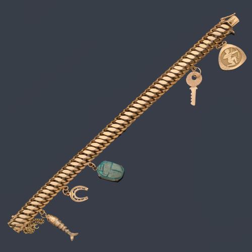  Pulsera con eslabones barbados con varios colgantes, realizado en oro amarillo de 18K.