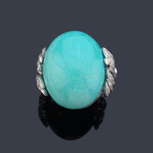  Anillo con gran turquesa talla cabujón con diseño curvado enriquecido con brillantes.