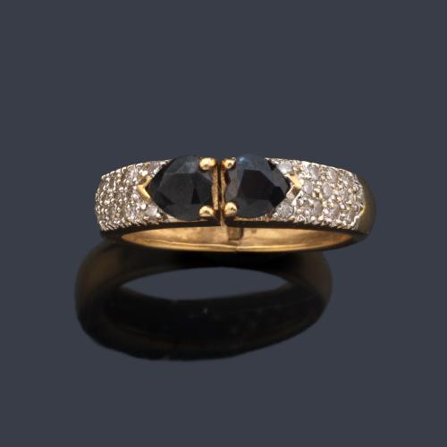 Anillo con dos zafiros talla oval y cuajado de brillantes en ambos brazos.
