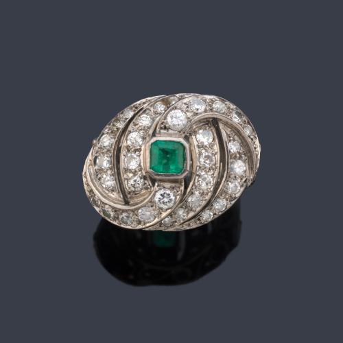 Anillo con esmeralda central con motivos ondulados cuajados de brillantes de aprox. 0,65 ct en total.