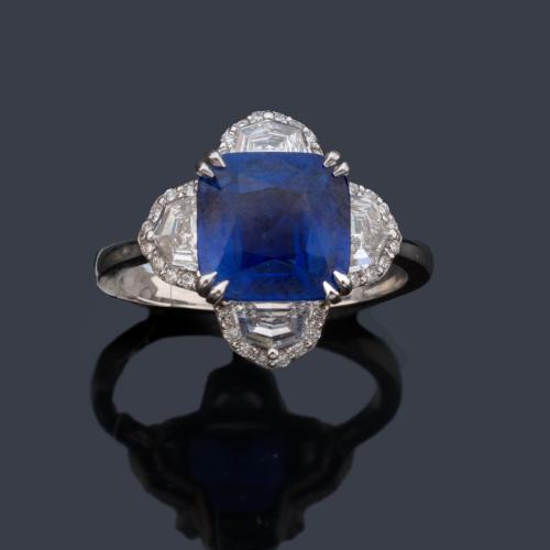  Anillo con zafiro de aprox. 3,43 ct con cuatro diamantes talla media luna y orla de brillantes de aprox. 1,01 ct en total.