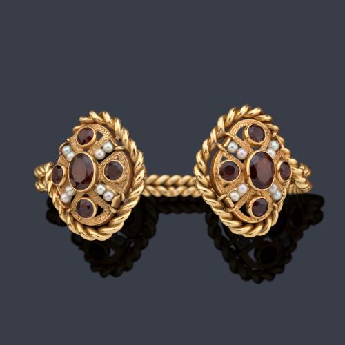  Pulsera rígida con dos motivos ovalados con perlitas y granates engastados en bisel.