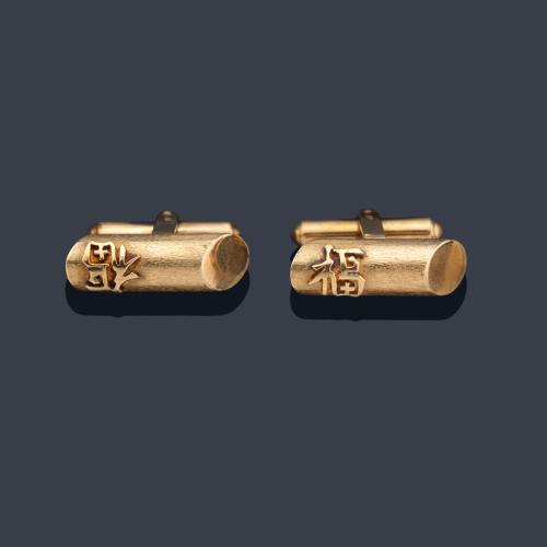 Gemelos con diseño tubular y letras orientales en montura de oro amarillo de 14K.