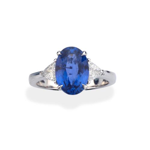  Anillo con zafiro talla oval de aprox. 3,48 ct con dos diamantes talla triángulo de aprox. 0,44 ct en total.