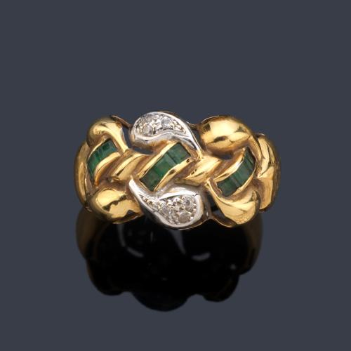 Anillo con bandas entrelazadas con esmeraldas calibradas y gema incolora en montura de oro amarillo de 18K.
