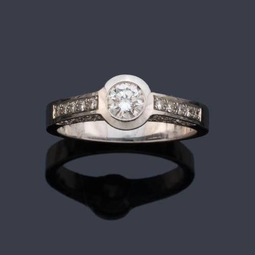  Anillo con brillante central de aprox. 0,35 ct con dos bandas de diamantes talla brillantes, en montura de oro blanco de 18K.