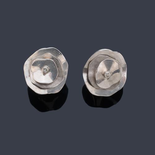 Pendientes cortos con diseño floral y brillante central en montura de oro blanco de 18K.