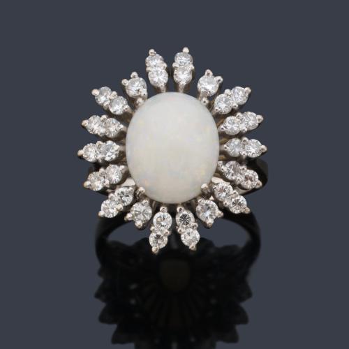 Anillo con ópalo blanco talla cabujón con orla de brillantes en montura de oro blanco de 18K.