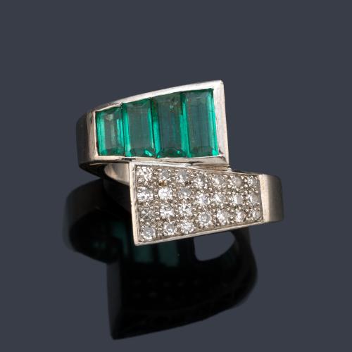  Anillo con dos brazos contrapeados con banda de esmeraldas de aprox. 0,70 ct en total y brillantes de aprox. 0,38 ct en total.