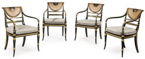  Conjunto de cuatro butacas Regencia, en madera ebonizada y parcialmente dorada, con respaldo y asiento de rejilla.