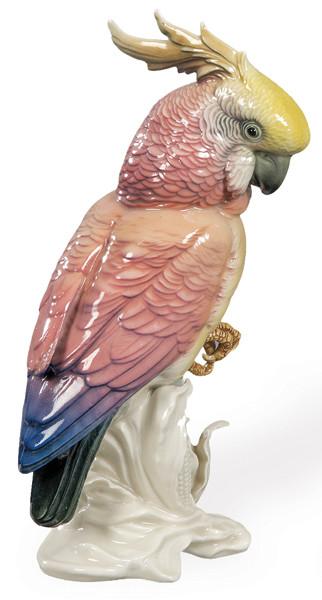  Figura de cacatúa crestada en porcelana, Rudolstadt-Volkstedt (Karl Ens). Porcelana moldeada de pasta blanca, esmaltes brillantes en naranja, amarillo, gris y negro, base con hojas estilizadas.​Alemania, h. 1930.