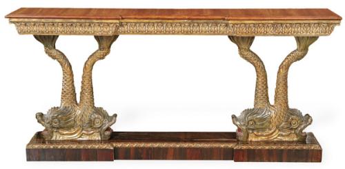  Consola estilo Imperio, con tapa rectangular recortada, con decoración de hojas de acanto talladas y doradas, sobre pedestales en forma de figuras de peces enfrentados pintados y dorados sobre plataforma. S. XX