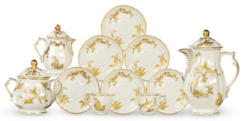 Juego de café de 12 servicios, modelo Reine Elisabeth, en porcelana Bernardaud & Compañía de Limoges, con fondo crema decorado con vegetación y pájaros del paraiso en dorado. Formado por 27 piezas