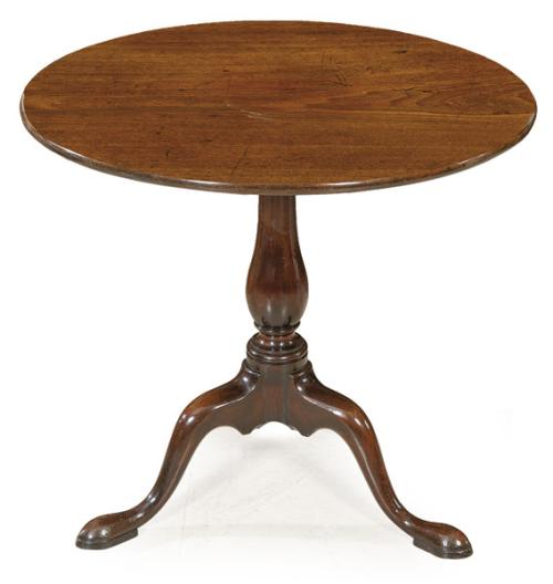  Mesa tilt-top Jorge II, con tapa circular en madera de caoba abatible, sobre pedestal torneado y tres patas ligeramente curvas.