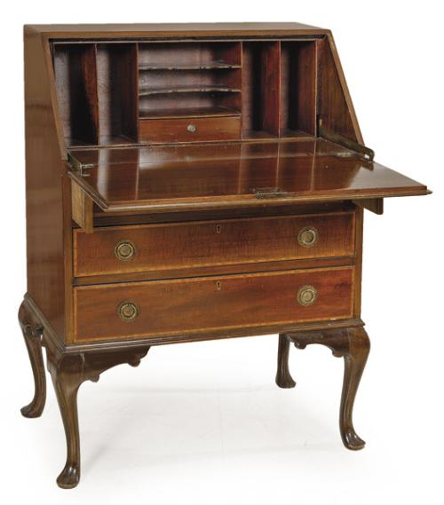 Bureau eduardino siguiendo modelos Jorge II, en madera de caoba con fileteado de boj, con tapa abatible, sobre tres cajones con tiradores de latón. Patas ligeramente cabriolé acabadas en almohadillas. Inglaterra, principios S. XX