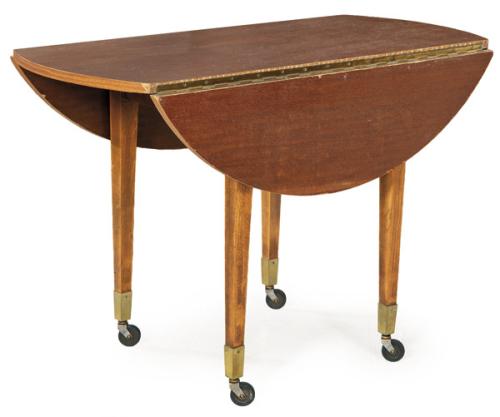  Mesa de comedor con tapa circular estilo Jorge III, con alas abatibles en madera de caoba, sobre patas rectas terminadas en ruedas.