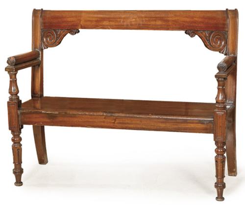 Banco Victoriano en madera de caoba, con respaldo recto, sobre montantes delanteros tallados.