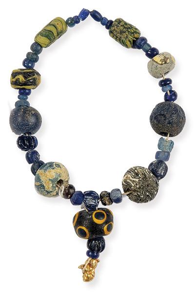 Cuentas romanas y sasánidas en vidrio y león en oro S. III - VI d.C.