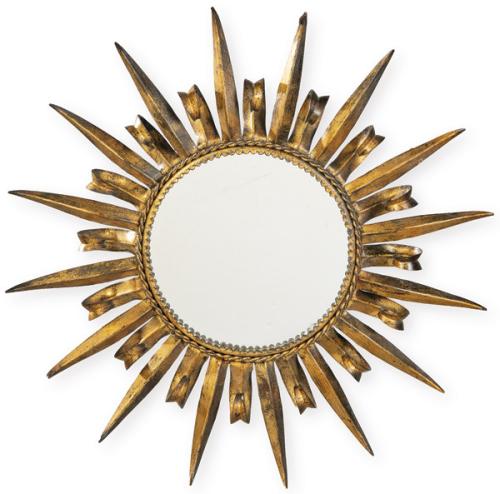 Espejo de pared tipo sol, con marco formado por rayos triangulares en chapa de latón chapado en oro, curvados en sección cóncava y ensamblados radialmente en torno a espejo circular plano de vidrio.