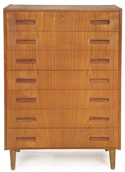 Cómoda alta con siete cajones largos y tiradores incrustados en madera de teca, sobre patas torneadas.