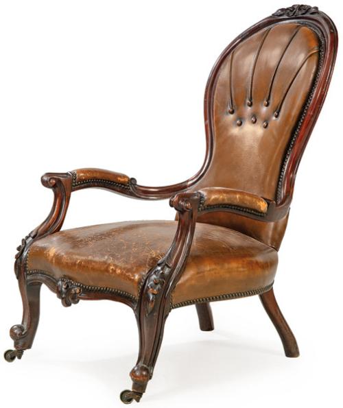  Butaca victoriana en madera de caoba tallada, con tapicería de cuero marrón.