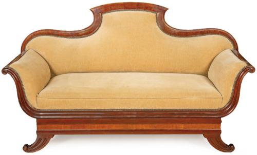 Canapé  imperio con respaldo recortado en madera de caoba y reposabrazos ligeramente curvos.